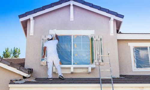 Busy House Painter Painting the Trim And Shutters of A Home.